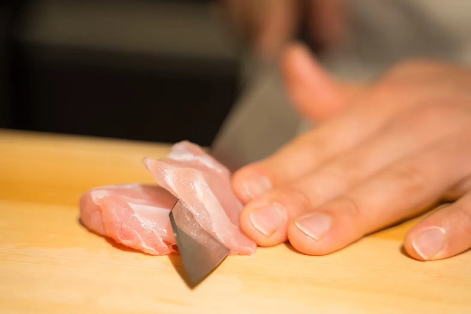 白身の魚に包丁を入れる手